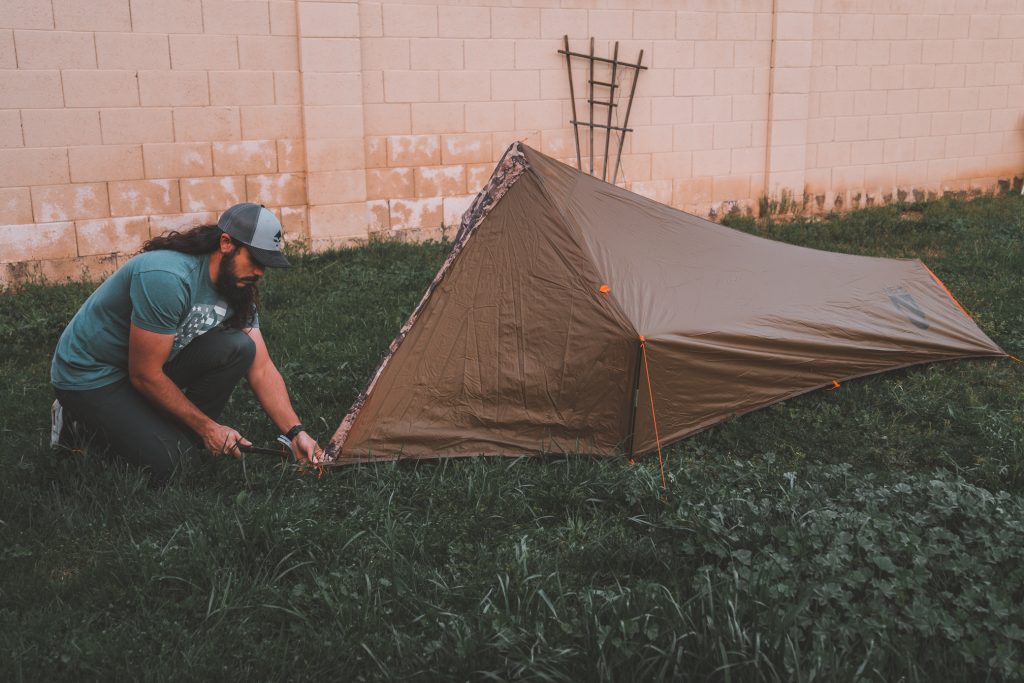 Josh from Dialed in Hunter setting up a backcountry shelter in his backyard