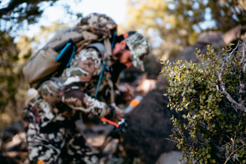 Josh from Dialed in Hunter putting on his backpack for a hunt in Arizona