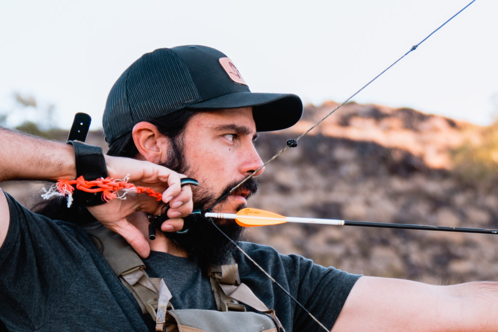 Josh Kirchner from Dialed in Hunter at full draw with a thumb button release aid