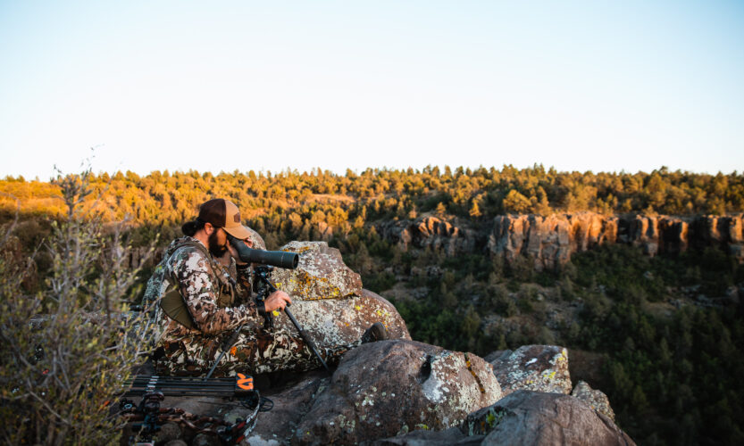 Josh Kirchner from Dialed in Hunter glassing with an angled spotting scope in the high desert of Arizona
