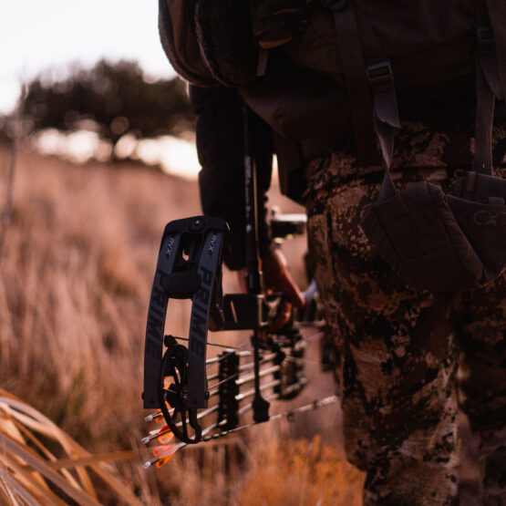 Josh Kirchner from Dialed in Hunter holding a bow at his side on an archery hunt for coues deer in Arizona