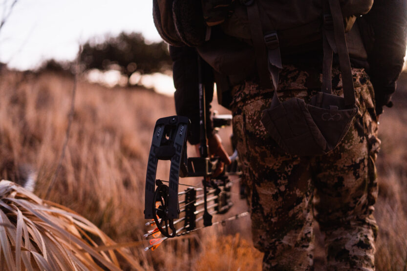 Josh Kirchner from Dialed in Hunter holding a bow at his side on an archery hunt for coues deer in Arizona