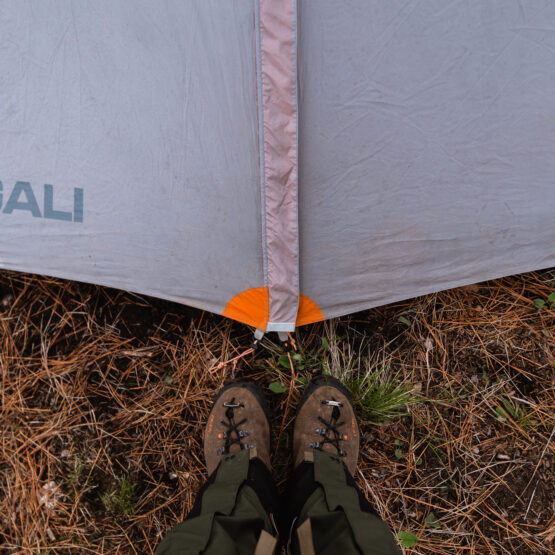 Standing at the door of a tent in the backcountry