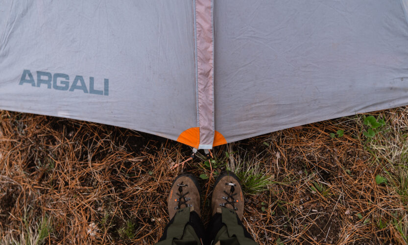 Standing at the door of a tent in the backcountry