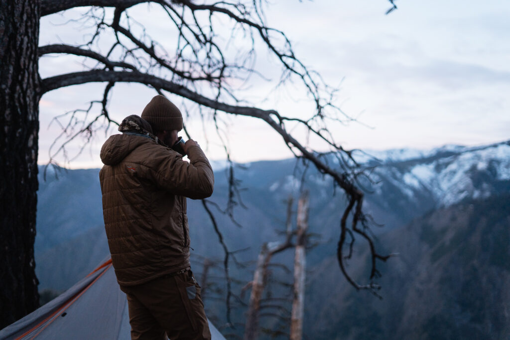 Josh Kirchner drinking a cup of coffee in the backcountry on a bear hunt