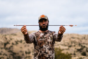 Josh Kirchner holding a Method Archery ZMR arrow after a successful coues deer hunt in Arizona
