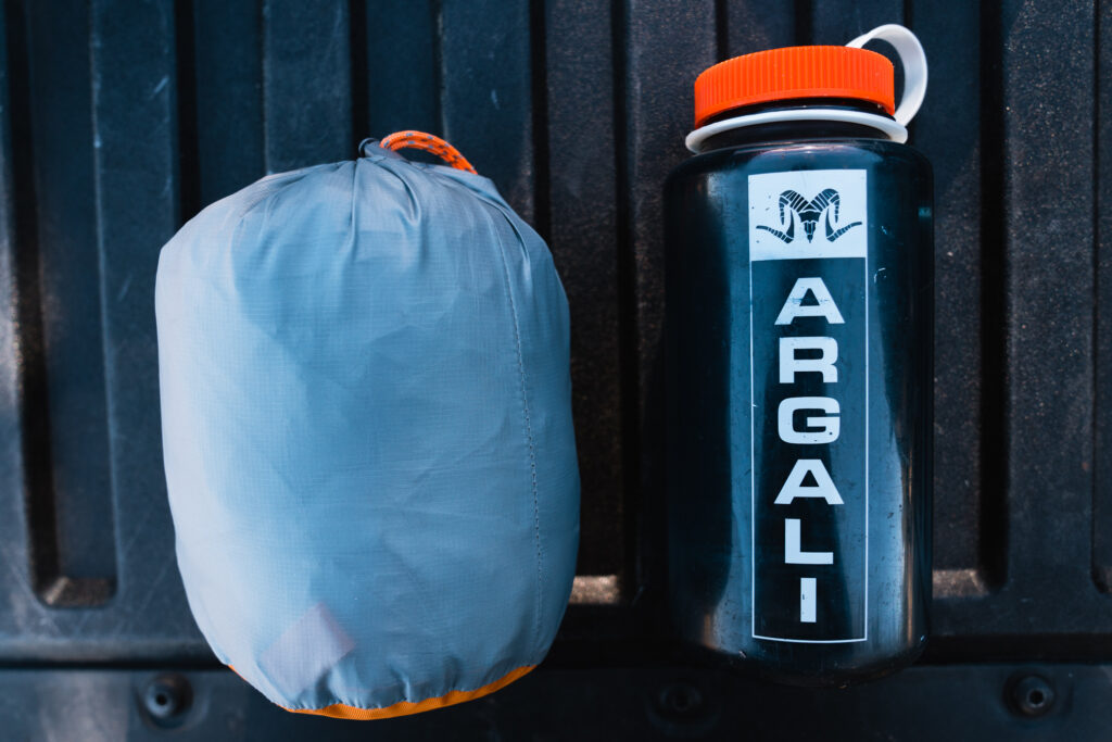 The Argali Owyhee 1p tent packed up next to a Nalgene bottle for size reference