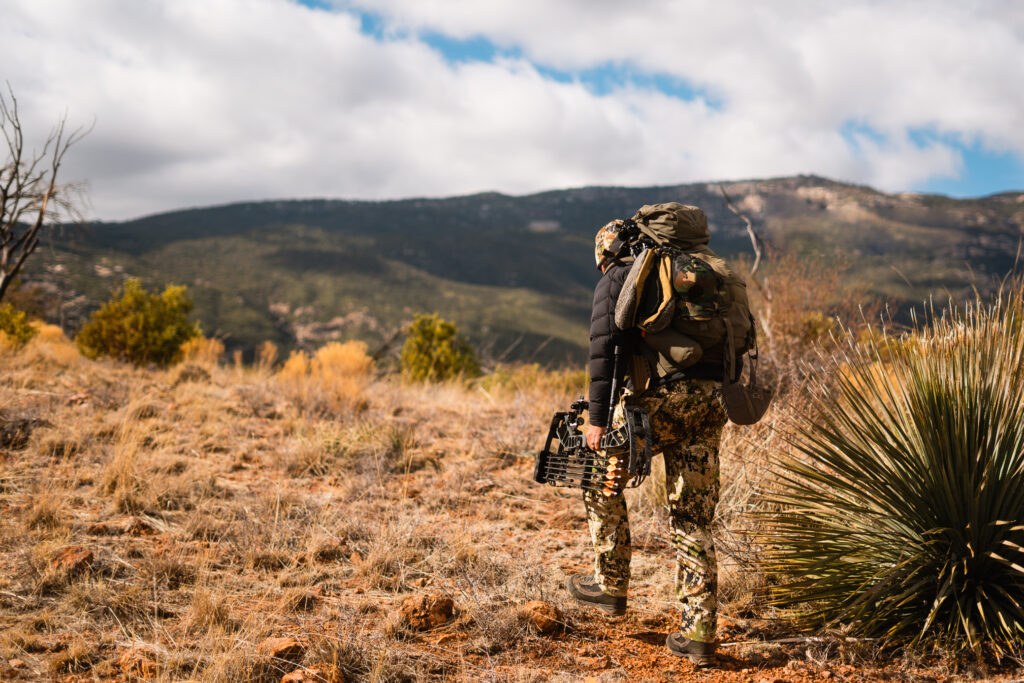 Josh Kirchner hiking off into the distance bowhunting coues deer in Arizona