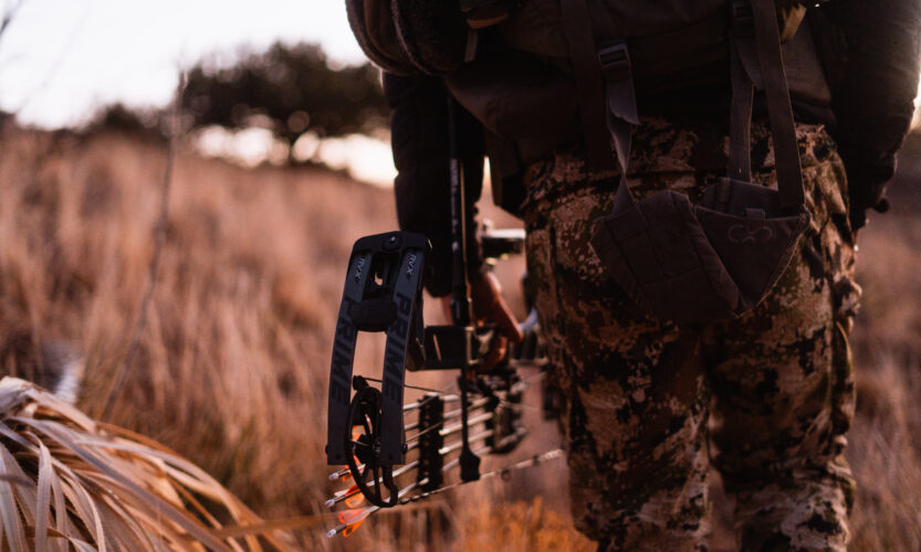 Josh Kirchner from Dialed in Hunter holding a bow at his side on an archery hunt for coues deer in Arizona