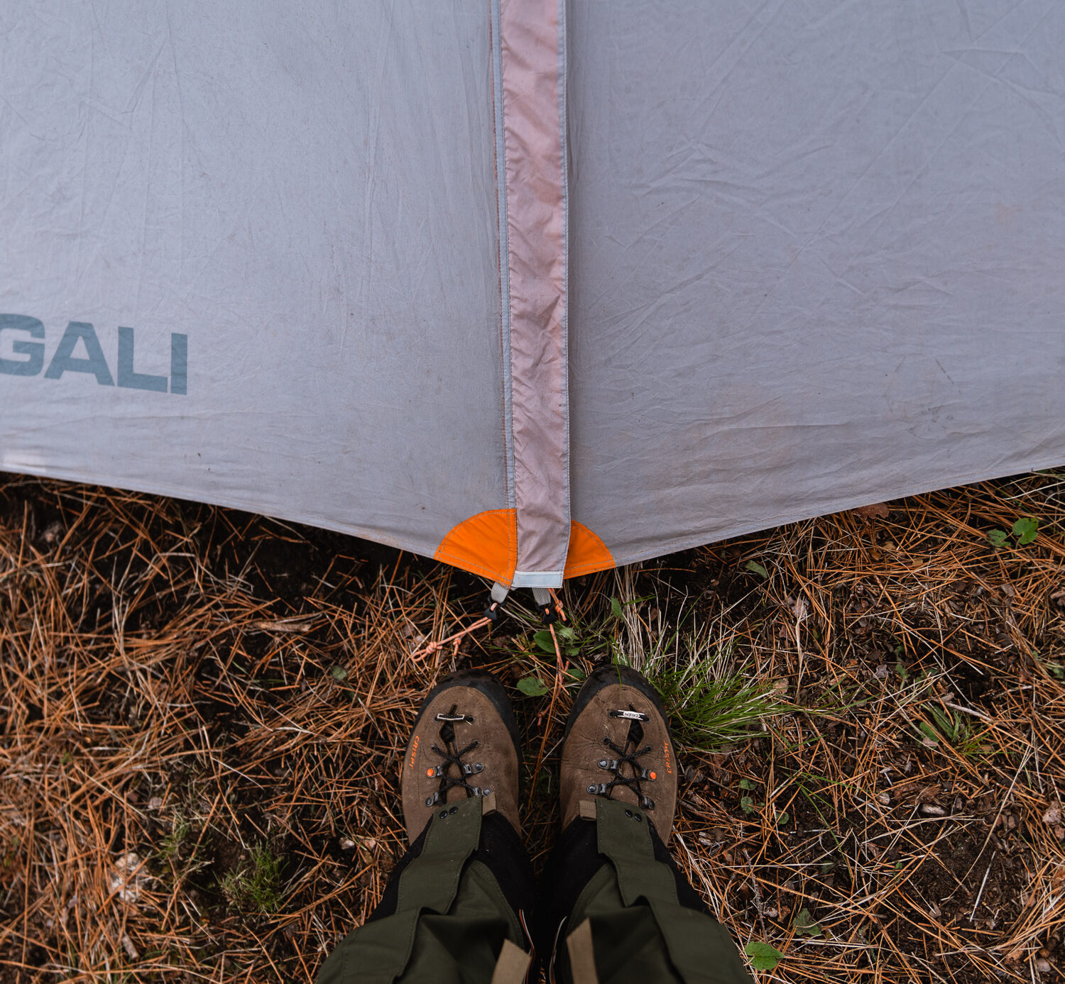 Standing at the door of a tent in the backcountry