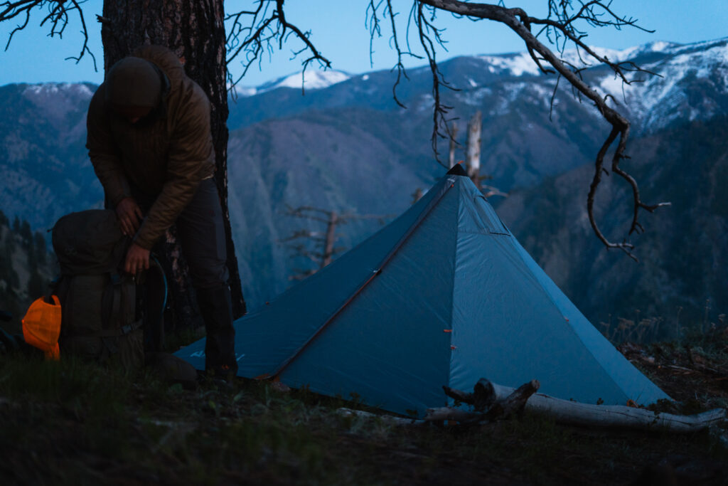 Josh Kirchner from Dialed in Hunter unloading his backpack near his tent on a backpack hunt for black bears in Idaho