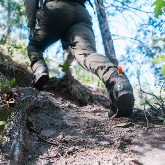 Josh Kirchner hiking up a steep mountain while scouting for black bears in Arizona