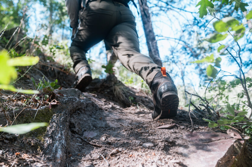 Josh Kirchner hiking up a steep mountain while scouting for black bears in Arizona
